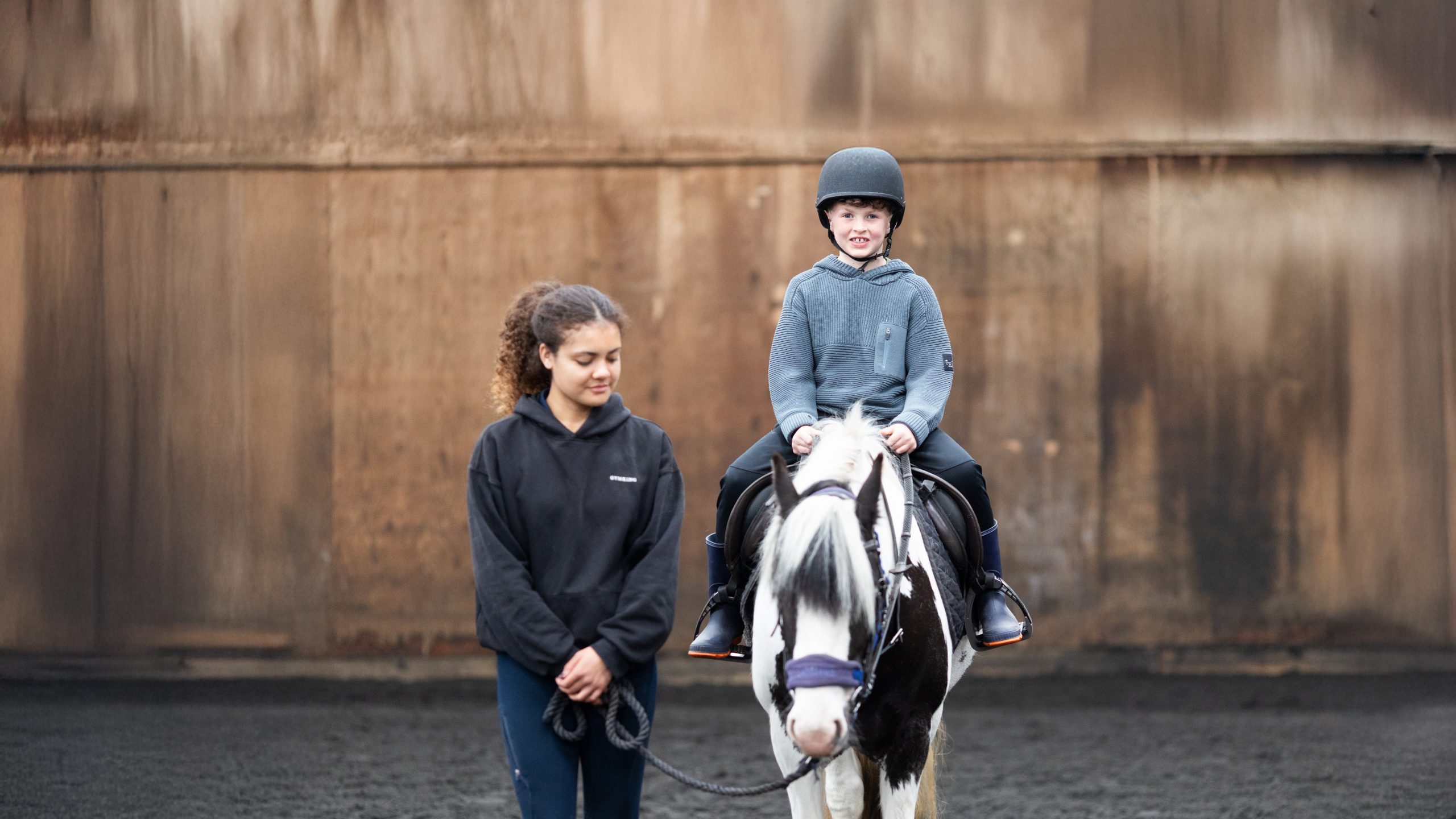 A young boy smiles as he rides a pony at the Bourne Vale Stables Open Day near Birmingham